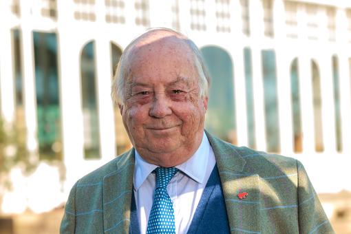 A head and shoulder portrait of an adult male in a suit