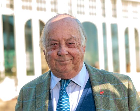A head and shoulder portrait of an adult male in a suit