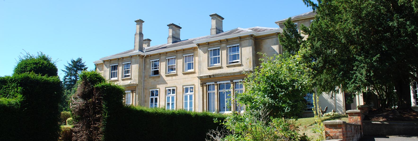 A view of Arlington Manor from the back looking over the yew hedges