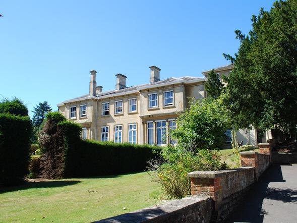 A view of Arlington Manor from the back looking over the yew hedges