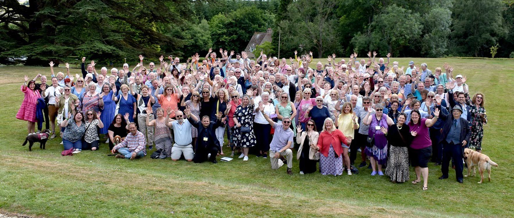 A large group of former pupils of Mary Hare School gather on the lawn in front of the manor.