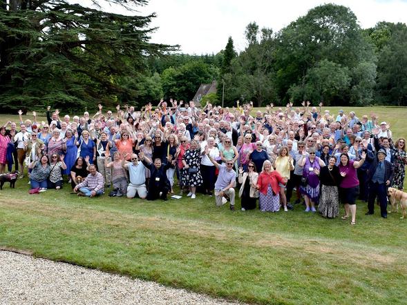 A large group of former pupils of Mary Hare School gather on the lawn in front of the manor.