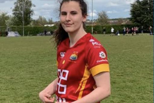 A young female is dressed in rugby sports kit