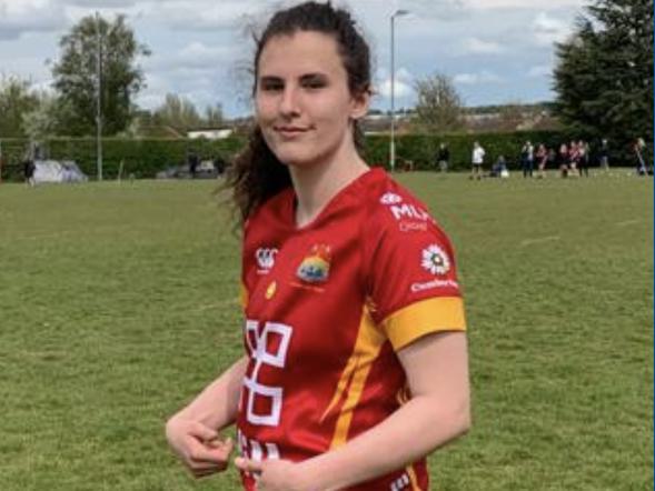 A young female is dressed in rugby sports kit