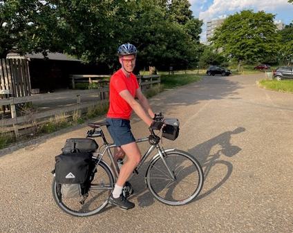 A male adult is on a bike.
