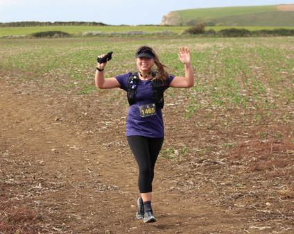 A female runner is waving in the countryside